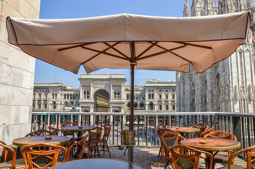 A drinks balcony overlooking Piazza Duomo in Milan, Italy on a summer day