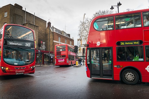 Three red London, England buses in an intersection