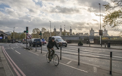 Cyclist on segregated cycling lane near Tower Hill in the City of London, UK