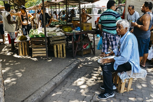 Older Brazilian man playing drums in a street market in Rio de Janeiro, Brazil