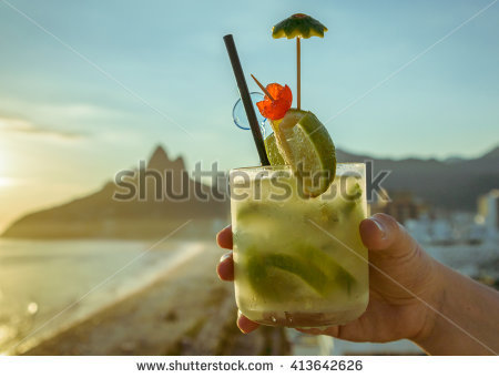 stock-photo-caipirinha-cocktail-with-a-kiwi-twist-with-rio-de-janeiro-brazil-beach-background-413642626