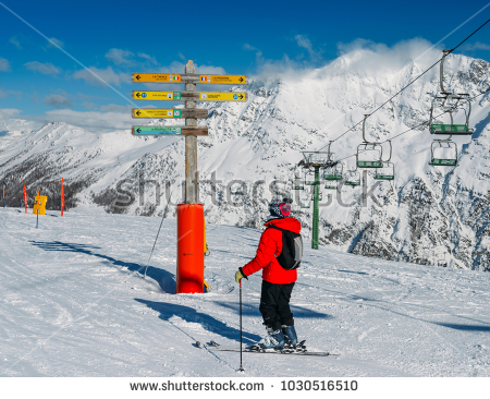 stock-photo-la-thuile-italy-feb-skier-looking-at-signpost-in-the-ski-resort-of-la-thuile-1030516510