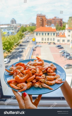 stock-photo-plate-of-shrimps-prawns-with-a-city-background-695905048