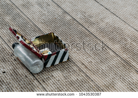 stock-photo-stripped-change-box-on-ground-supported-open-by-a-water-bottle-asking-for-donations-from-out-of-1043530387