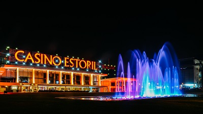 Facade of the Casino Estoril with colourful fountain show at night. Casino Estoril is one of the largest casinos in Europe and inspiration for Ian Fleming's Casino Royale