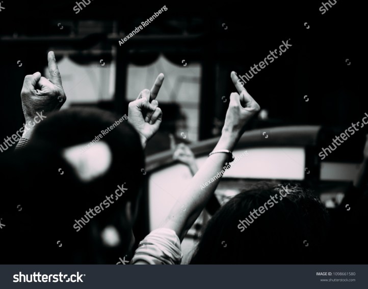 stock-photo-three-unidentifiable-protestors-give-the-middle-finger-rude-gesture-1098661580
